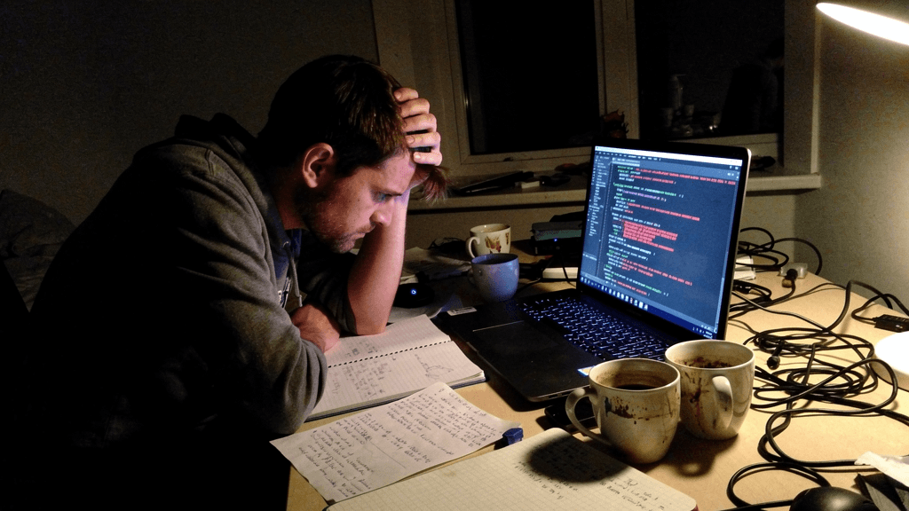 A lone learner stuck and frustrated at a laptop late at night