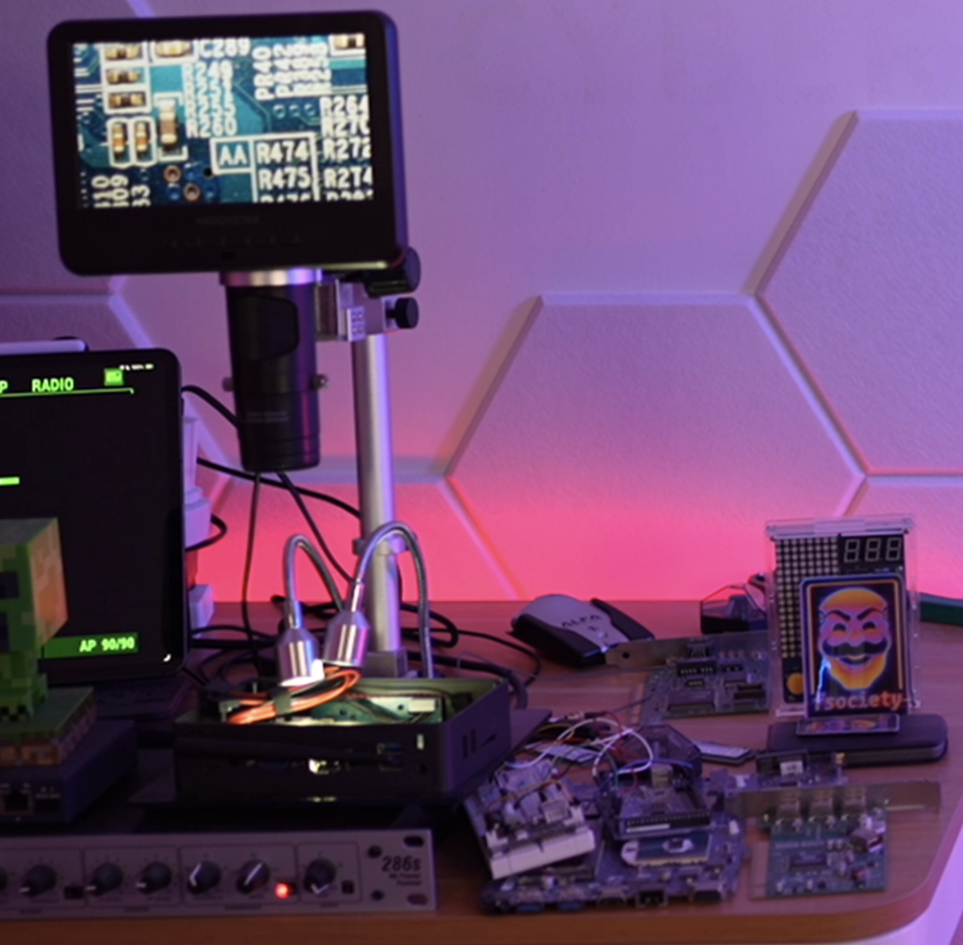 A digital microscope on a hardware bench magnifying a circuit board to read the tiny component reference markings